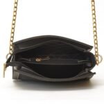 Stylish black cross body bag with gold chain and luxurious suede front panel, ideal for a sophisticated look.