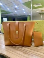 The spacious Caramel Tote Bag, available in a rich brown color, features a secure design with a locking system, a small pouch, and a comfortable leather strap. It offers ample storage space and is available in Pakistan.